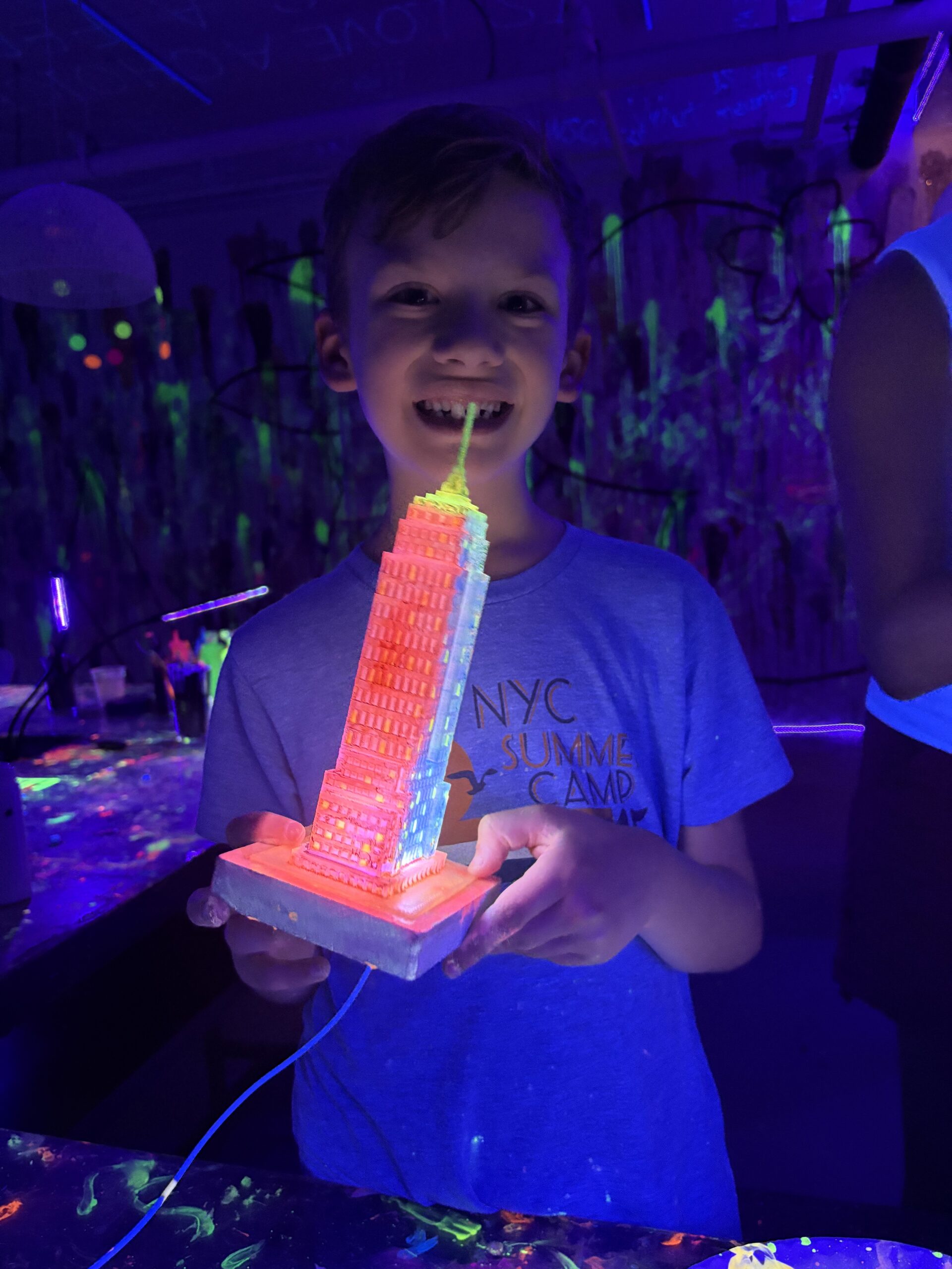 Group painting under blacklight at a glow paint and sip class at Cozy Art Land